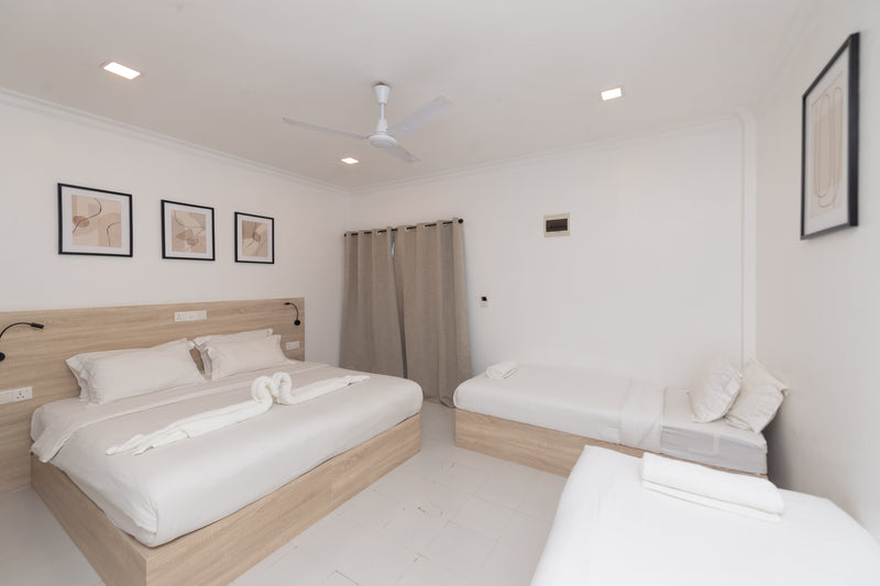 Quadruple family room with beds for four and a ceiling fan at Nala Island Village