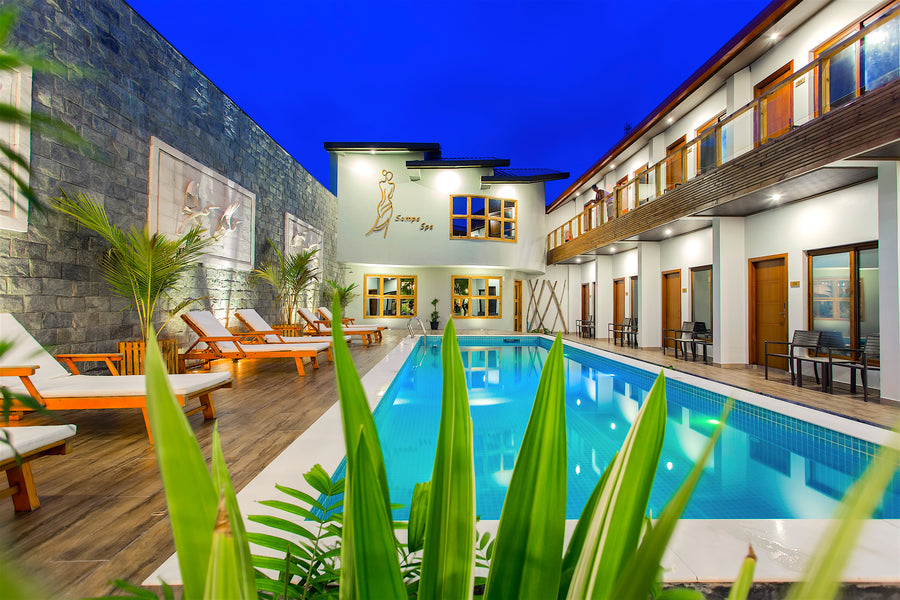 Courtyard pool with loungers between the room wings at Kaani Village & Spa