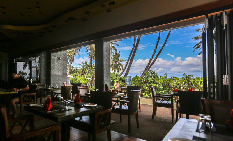 Open-sided restaurant at Kaani Grand Seaview looking out to palms and the sea