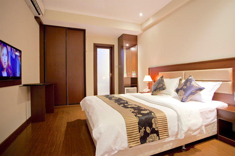 Deluxe double room at Kaani Beach Hotel with a king bed and wall-mounted TV