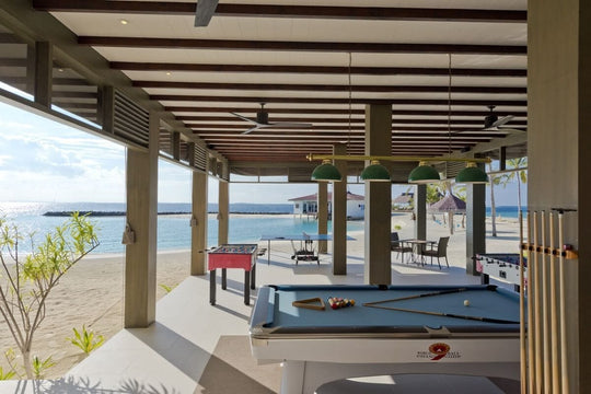 The beachside games room at Grand Park Kodhipparu, pool tables and table football