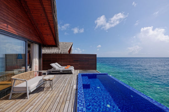 A Reef Pool Water Villa deck at Grand Park Kodhipparu, a lounge area and plunge pool above the ocean