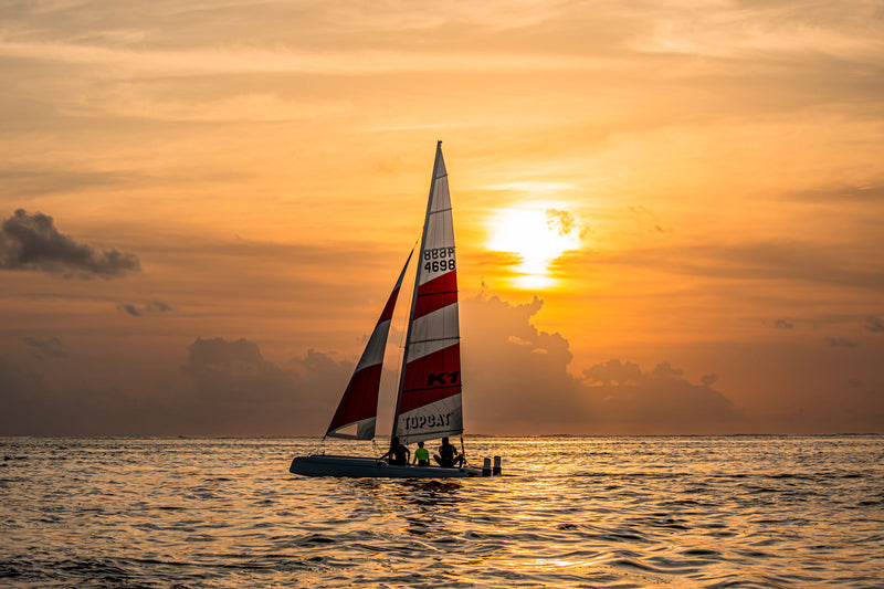 A catamaran off You & Me Maldives at sunset.