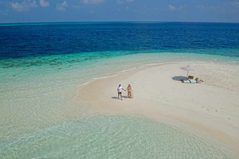 Two guests on the sandbank at You & Me Maldives.