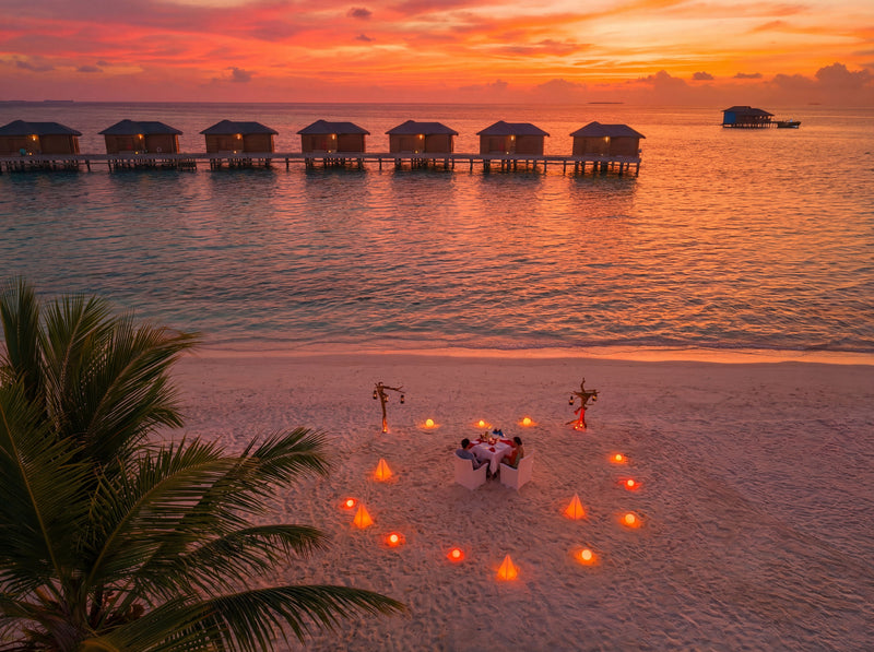 A dinner laid on the beach at sunset at You & Me Maldives.