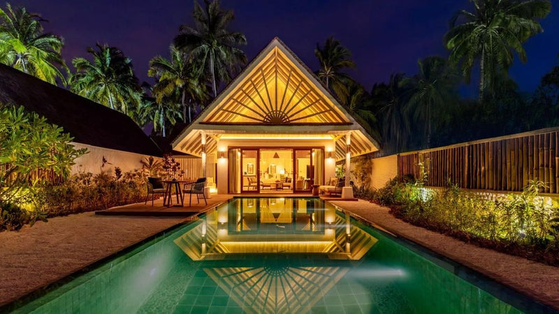 A beach villa lit at night at RAH GILI Maldives.