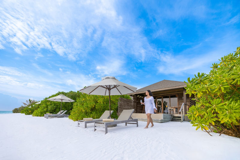 Jawakara Islands Maldives, Lhaviyani Atoll: the sand in front of a Dheru beach pool villa, with sun loungers under a thatched umbrella