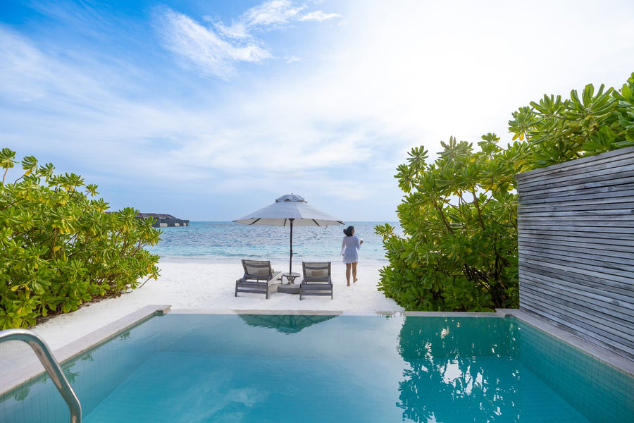 Jawakara Islands Maldives, Lhaviyani Atoll: a private pool, loungers and an umbrella on the sand at a Dheru beach pool villa