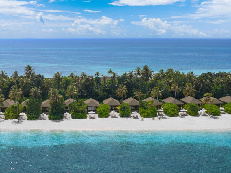 Jawakara Islands Maldives, Lhaviyani Atoll: Dheru beach villas among palms along the shore, seen from the air