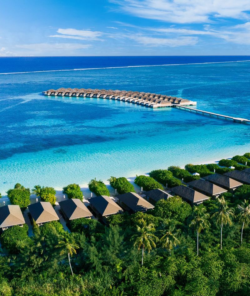 Jawakara Islands Maldives, Lhaviyani Atoll: the long jetty of Mabin water villas reaching out across the lagoon from the beach villas