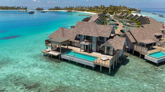 The overwater villas at ananea Madivaru Maldives from the air, thatched roofs above the lagoon