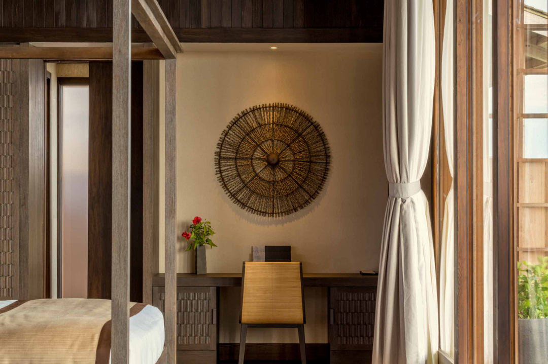 Kudadoo Maldives Private Island, Lhaviyani Atoll — writing desk and woven sunburst wall panel in the corner of a residence bedroom