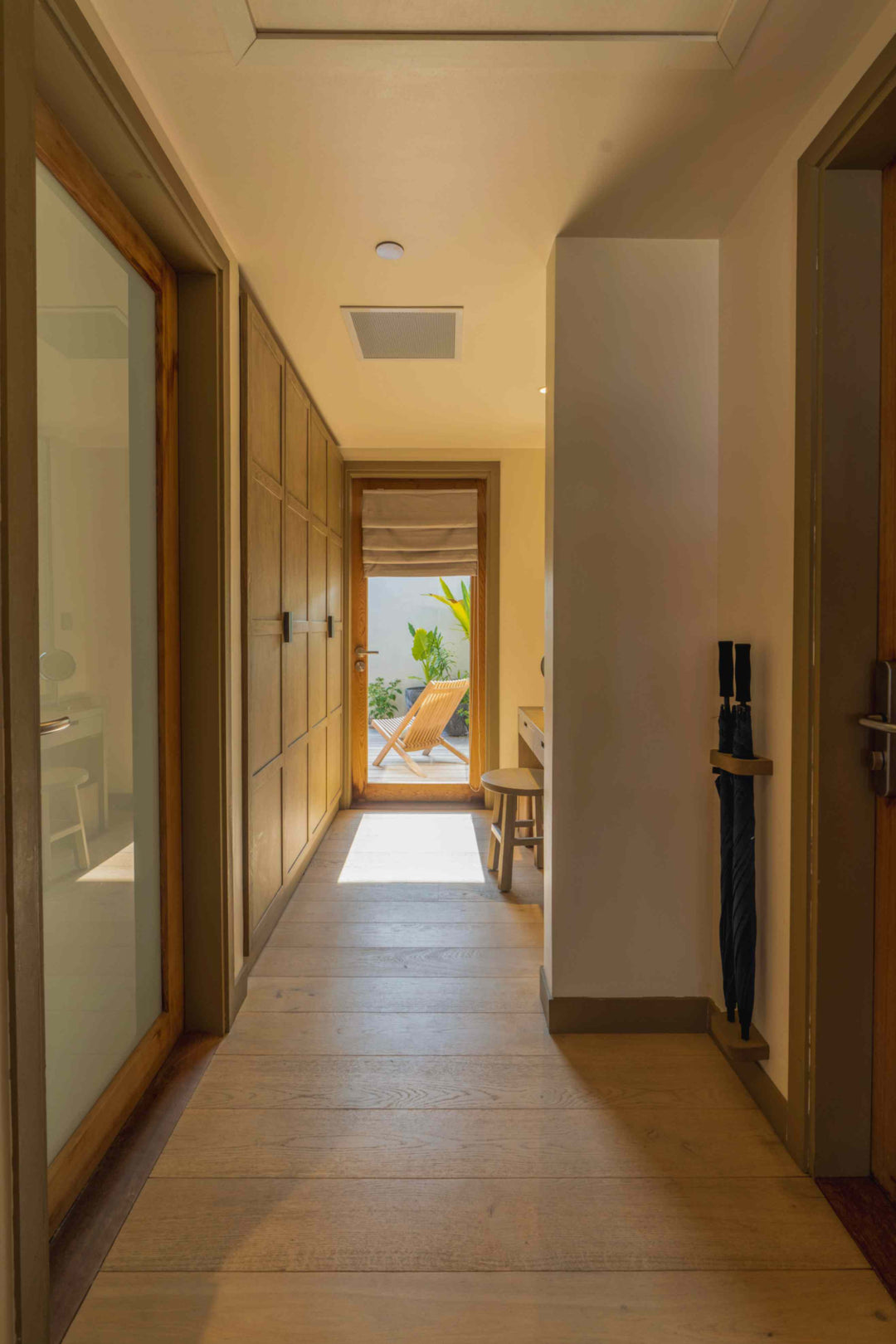Kagi Maldives Resort &amp; Spa, North Malé Atoll — entrance hallway of a villa, with fitted wardrobes and a doorway opening onto the sunlit terrace