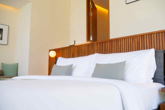 A made bed at ananea Madivaru Maldives against a fluted timber headboard