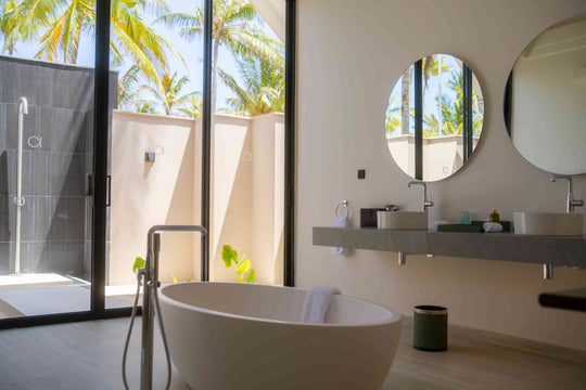 A villa bathroom at ananea Madivaru Maldives, freestanding bath and twin basins beside an open-air shower