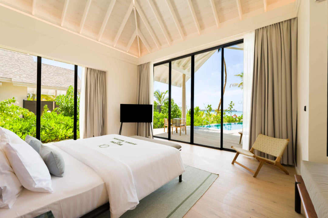 A Beach Pool Villa bedroom at ananea Madivaru Maldives looking out to the terrace and the pool
