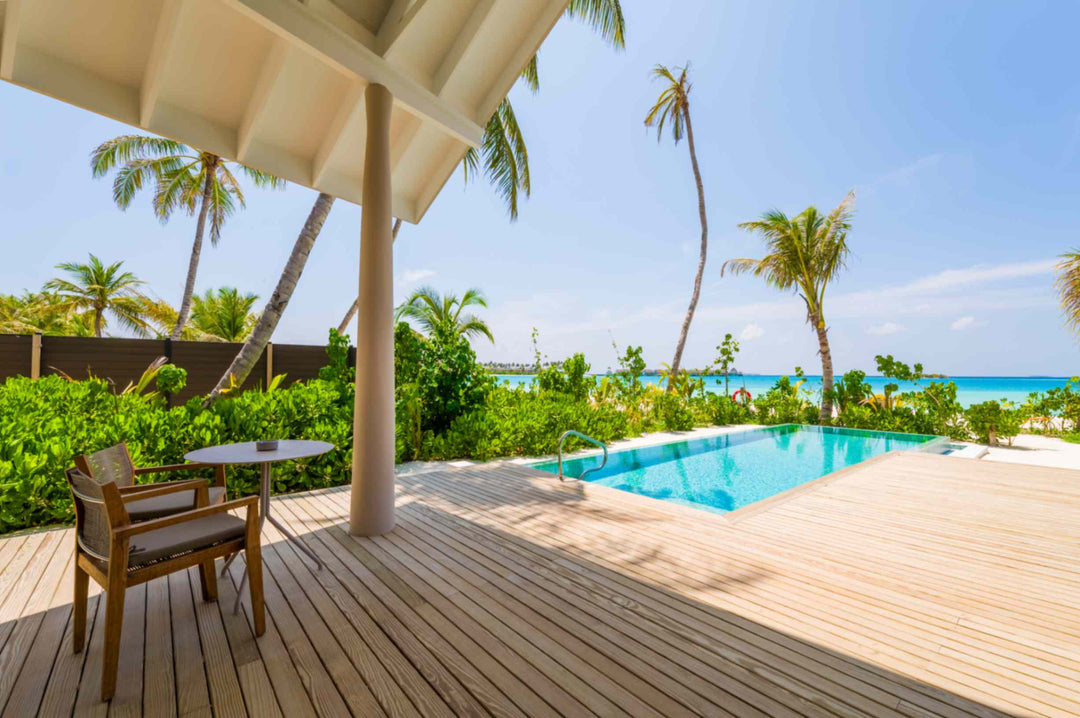 The shaded terrace of a Beach Pool Villa at ananea Madivaru Maldives, table and chairs beside the pool with the sea behind