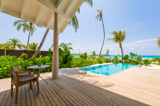 The shaded terrace of a Beach Pool Villa at ananea Madivaru Maldives, table and chairs beside the pool with the sea behind