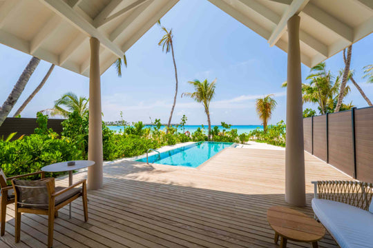 The pool of a beach villa at ananea Madivaru Maldives, the sea visible past the palms beyond the wall