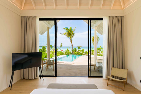 The view from a villa bedroom at ananea Madivaru Maldives out to the pool and the lagoon