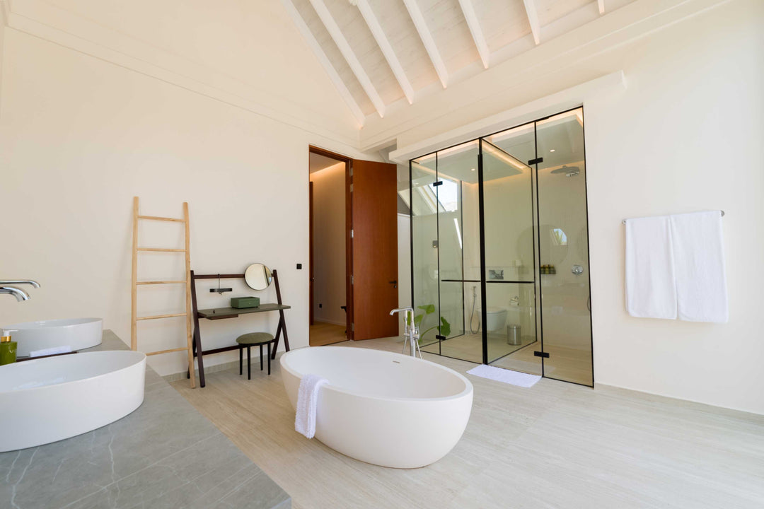 A freestanding bath beside a ladder rail in a villa bathroom at ananea Madivaru Maldives