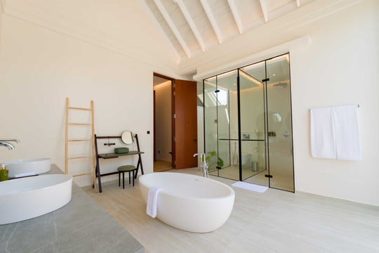 A freestanding bath beside a ladder rail in a villa bathroom at ananea Madivaru Maldives