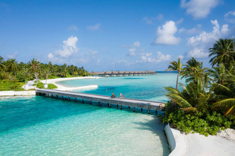 Couple cycling across the bridge linking the two islands at Niyama Private Islands