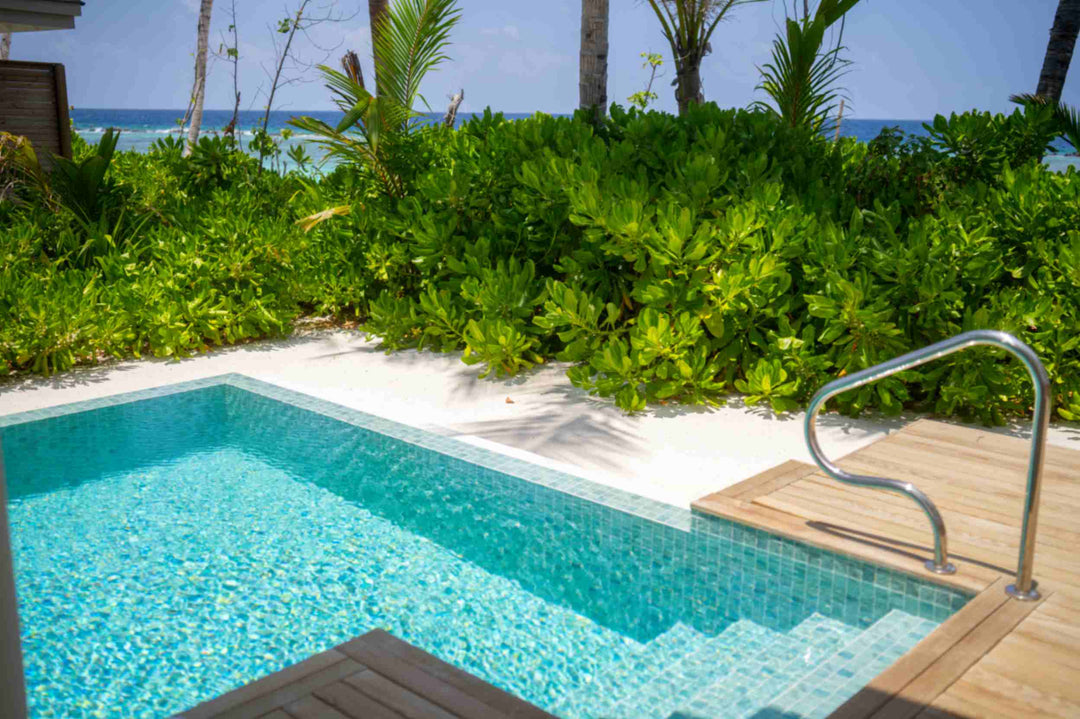 The private pool of a beach villa at ananea Madivaru Maldives, steps down into it with dense greenery behind