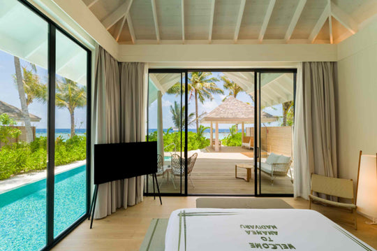 A beach villa at ananea Madivaru Maldives seen across its pool, the bedroom open to the terrace