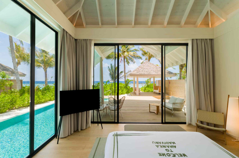A beach villa at ananea Madivaru Maldives seen across its pool, the bedroom open to the terrace