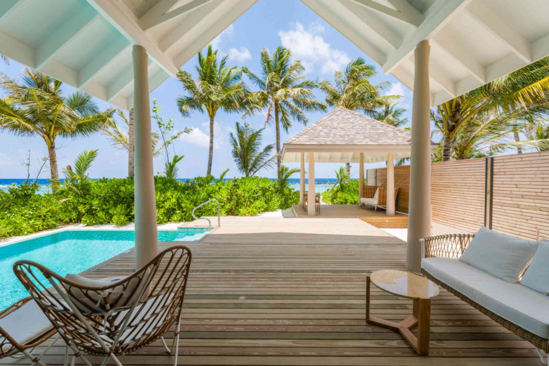 The shaded terrace of a beach villa at ananea Madivaru Maldives, pool alongside and the sea through the palms