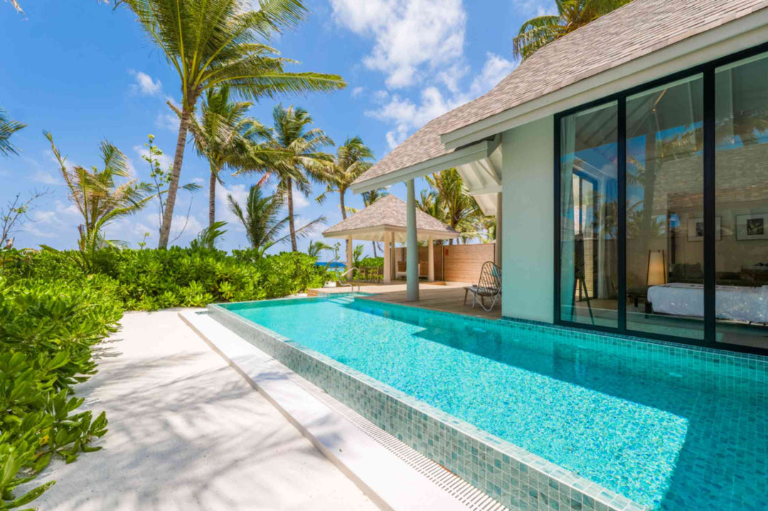 The pool of a Deluxe Beach Pool Villa at ananea Madivaru Maldives running towards the beach and the palms