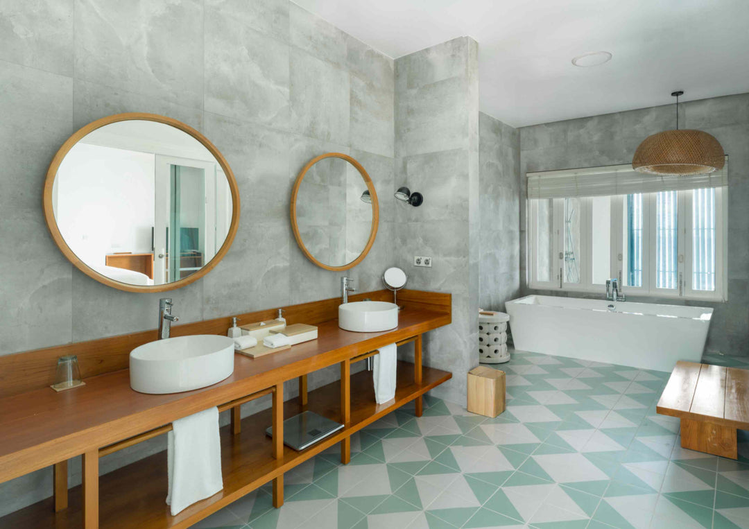 A Sunset Water Pool Villa bathroom at Amilla Maldives, twin round basins and a freestanding tub