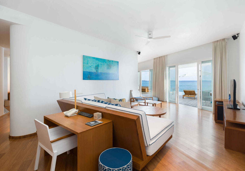 The living and dining area of a Lagoon Water Pool Villa at Amilla Maldives, with doors onto the deck
