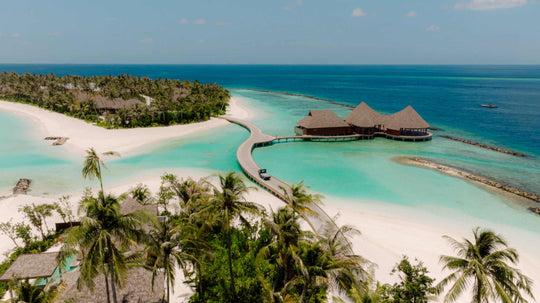 The overwater restaurant at ananea Madivaru Maldives from the air, reached by a curving jetty from the beach