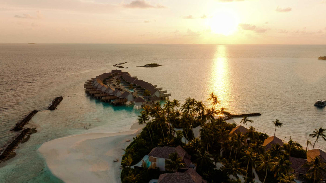 Sunset over ananea Madivaru Maldives from the air, the overwater villas silhouetted against the water