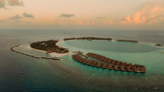 ananea Madivaru Maldives from the air, the overwater villas reaching into a wide turquoise lagoon