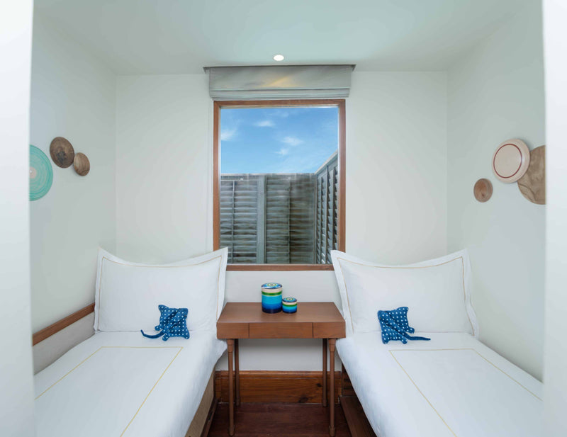 Twin beds in the children's room of a family villa at Anantara Kihavah Maldives Villas