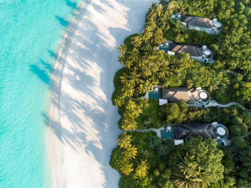 The shallows off the Beach Pool Villas at Anantara Kihavah Maldives Villas from the air, sand giving way to clear water