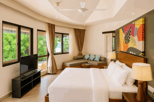 Angsana Velavaru, Dhaalu Atoll — twin bedroom in the three-bedroom villa, with a sofa along the window
