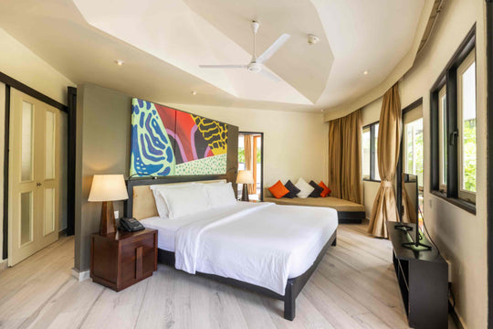 Angsana Velavaru, Dhaalu Atoll — twin beds made up side by side in a family villa, under bright wall art