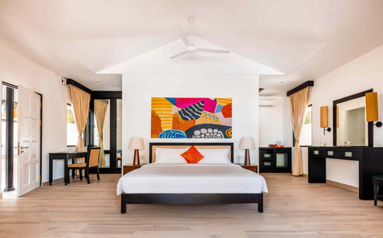 Angsana Velavaru, Dhaalu Atoll — Deluxe Beachfront Pool Villa bedroom with bright wall art and a writing desk