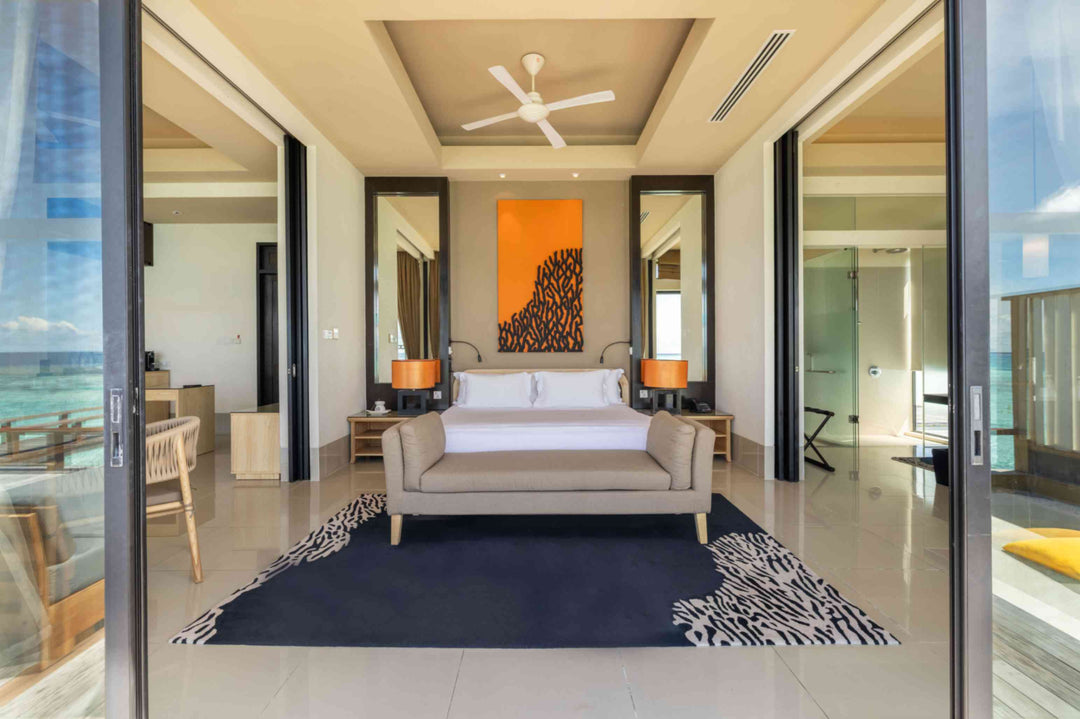 Angsana Velavaru, Dhaalu Atoll — bedroom of the Deluxe InOcean Two-Bedroom Pool Villa, with a sofa at the foot of the bed