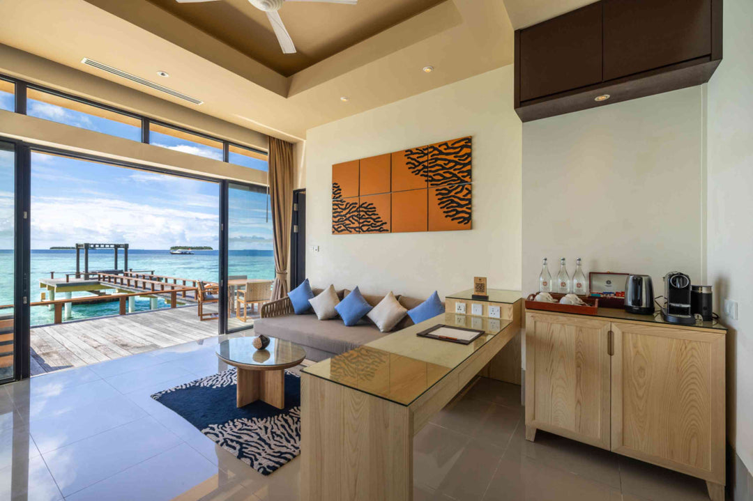Angsana Velavaru, Dhaalu Atoll — living area of the two-bedroom overwater villa, with a banquette and a coffee counter