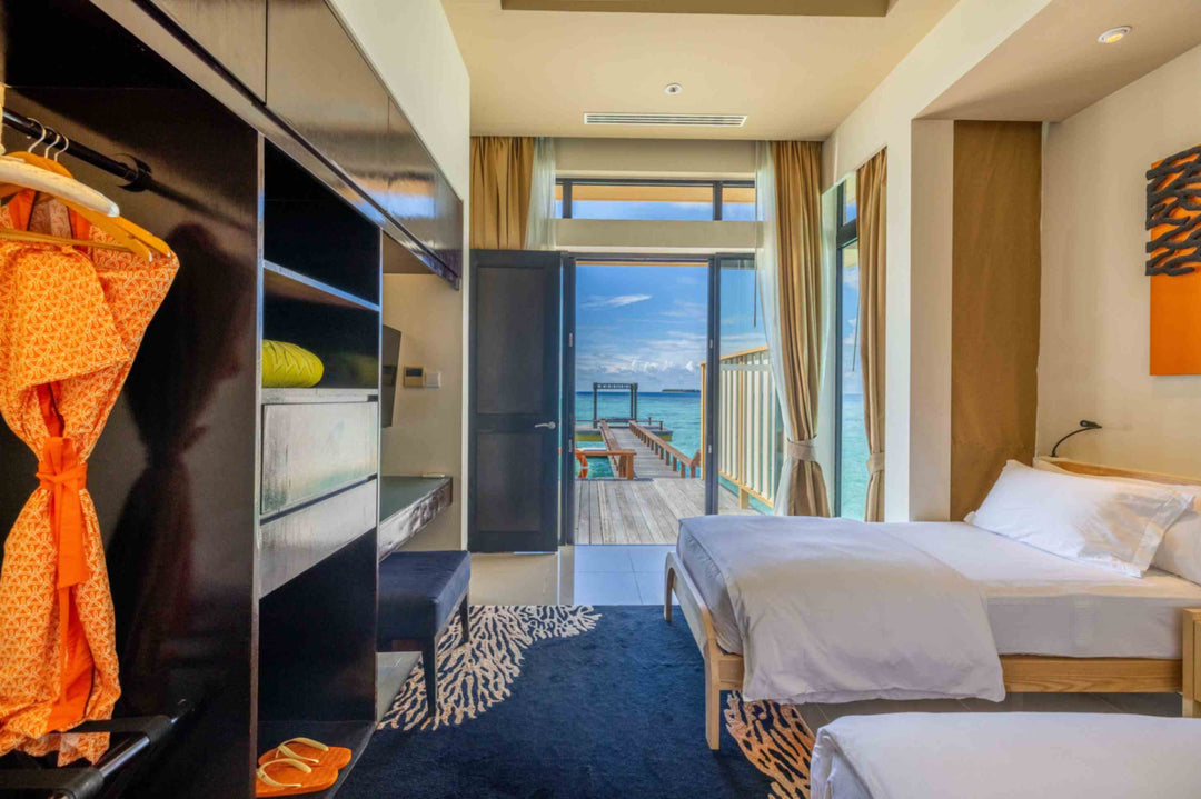 Angsana Velavaru, Dhaalu Atoll — twin bedroom in the two-bedroom overwater villa, with the wardrobe in the foreground