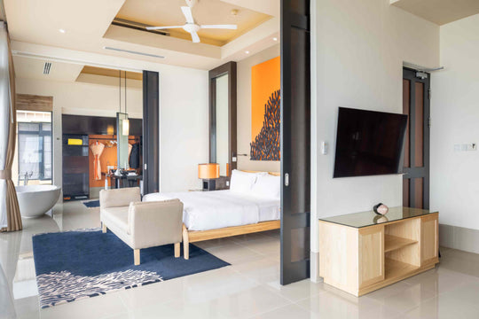 Angsana Velavaru, Dhaalu Atoll — Deluxe InOcean villa bedroom, with the bathroom visible through the doorway