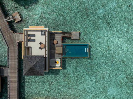 Angsana Velavaru, Dhaalu Atoll — drone view straight down onto an InOcean villa, its deck and infinity pool over the reef