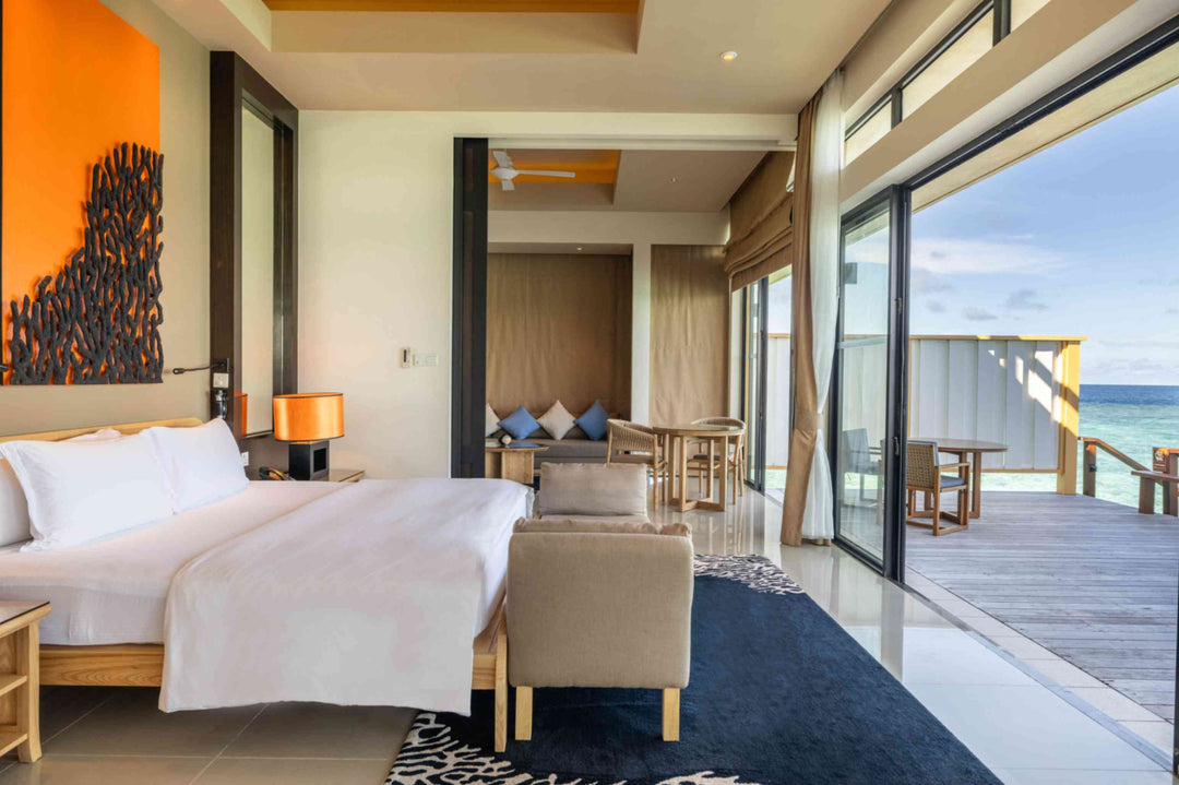 Angsana Velavaru, Dhaalu Atoll — InOcean villa bedroom looking out through the doors to the deck and the lagoon