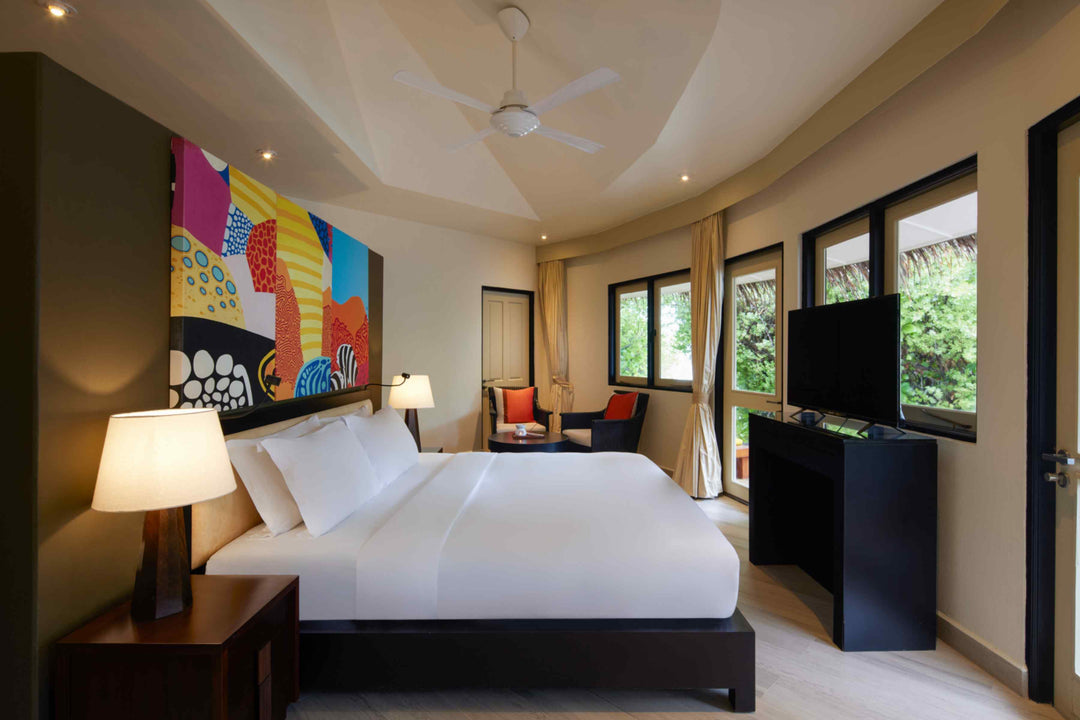 Angsana Velavaru, Dhaalu Atoll — two-bedroom pool villa king bedroom, with wall art and a seating corner