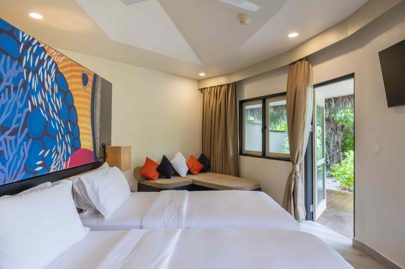 Twin beds in the second bedroom of the two-bedroom pool villa at Angsana Velavaru, with a daybed under the window.